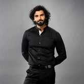 Man wearing a premium black shirt against a gray background