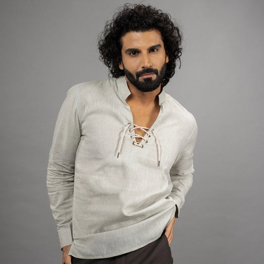 A maritime‑inspired lace‑up linen shirt with roll‑up sleeves, metal eyelets, and coconut shell button closures.