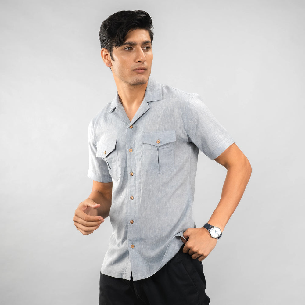 Man wearing a  premium Grey Colour linen camp‑collar shirt with dual chest pockets finished with natural coconut shell buttons blends comfort with refined adventure‑ready style.
