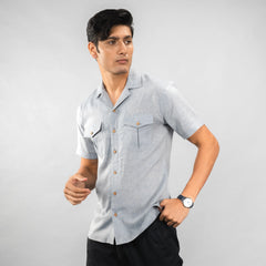 Man wearing a  premium Grey Colour linen camp‑collar shirt with dual chest pockets finished with natural coconut shell buttons blends comfort with refined adventure‑ready style.