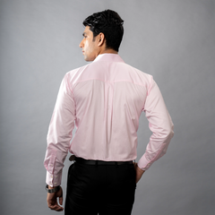 Man wearing a formal  light pink shirt against a gray background