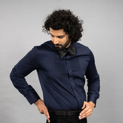 Man wearing a Maritime Blue shirt with a bow tie against a grey background