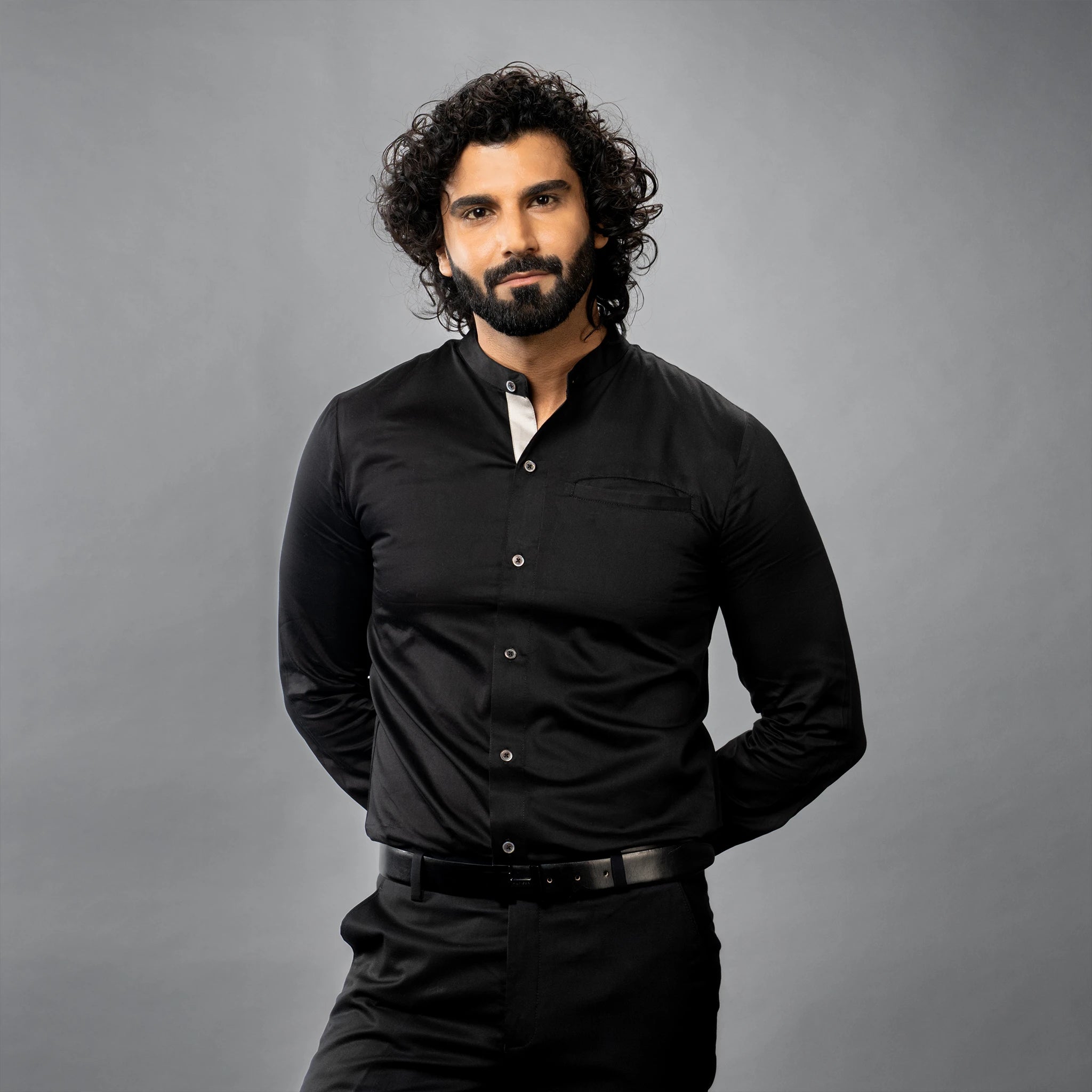 Man wearing a premium black shirt against a gray background