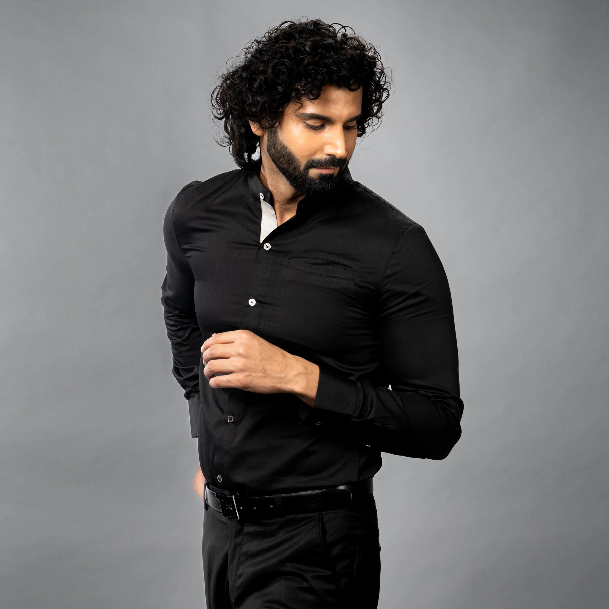 Man wearing Cut in luxurious Giza Cotton,  a black shirt against a grey background