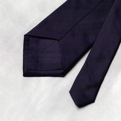 back of Navy blue tie on a light gray background