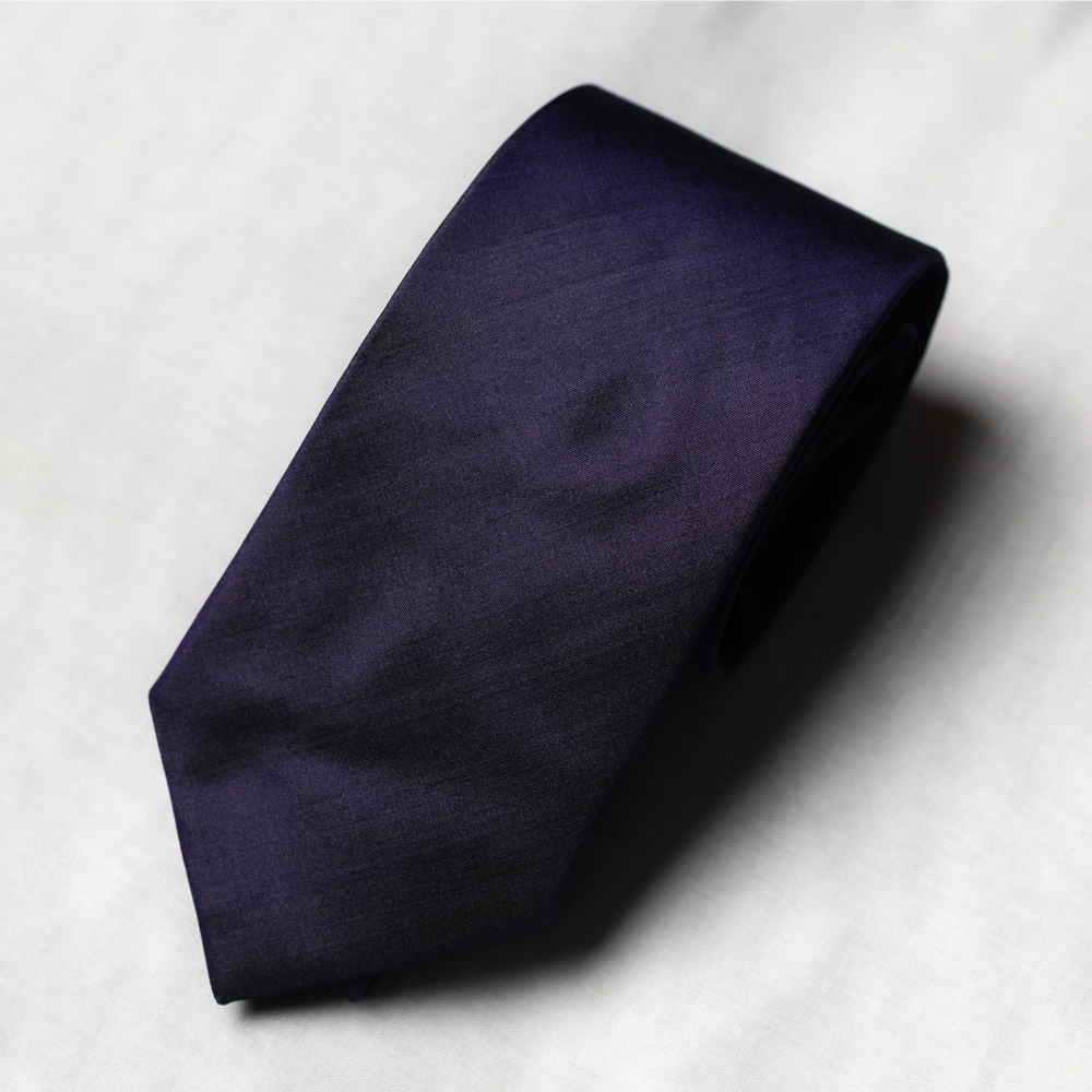 Navy blue tie on a light gray background