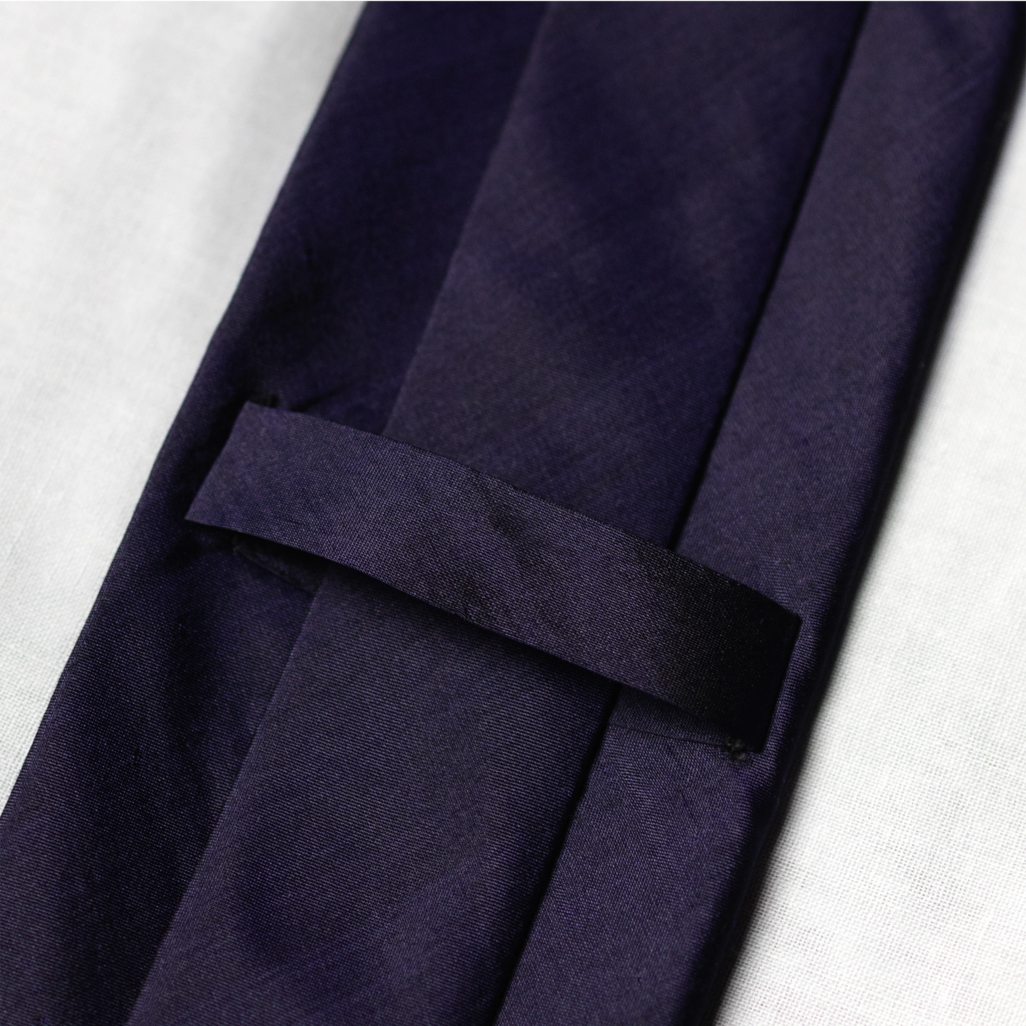 Navy blue tie keeper loop on a white background