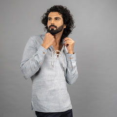 Man wearing a Faded Denim long-sleeve shirt with a lace-up front against a grey background.