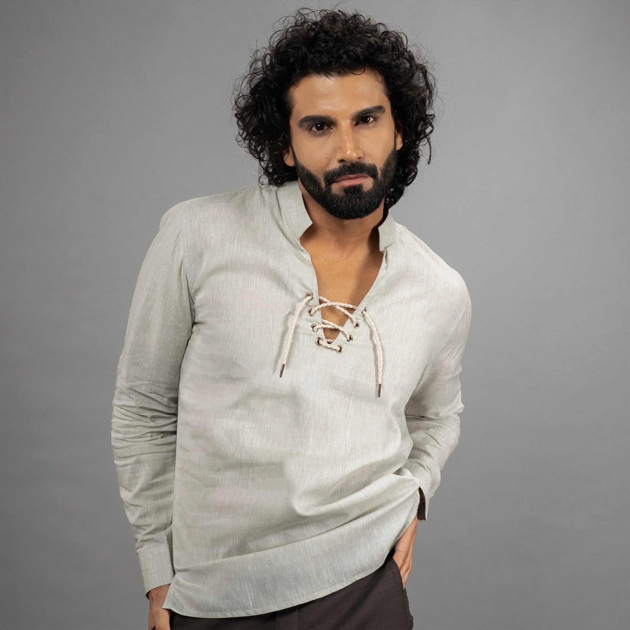 A maritime‑inspired lace‑up linen shirt with roll‑up sleeves, metal eyelets, and coconut shell button closures.