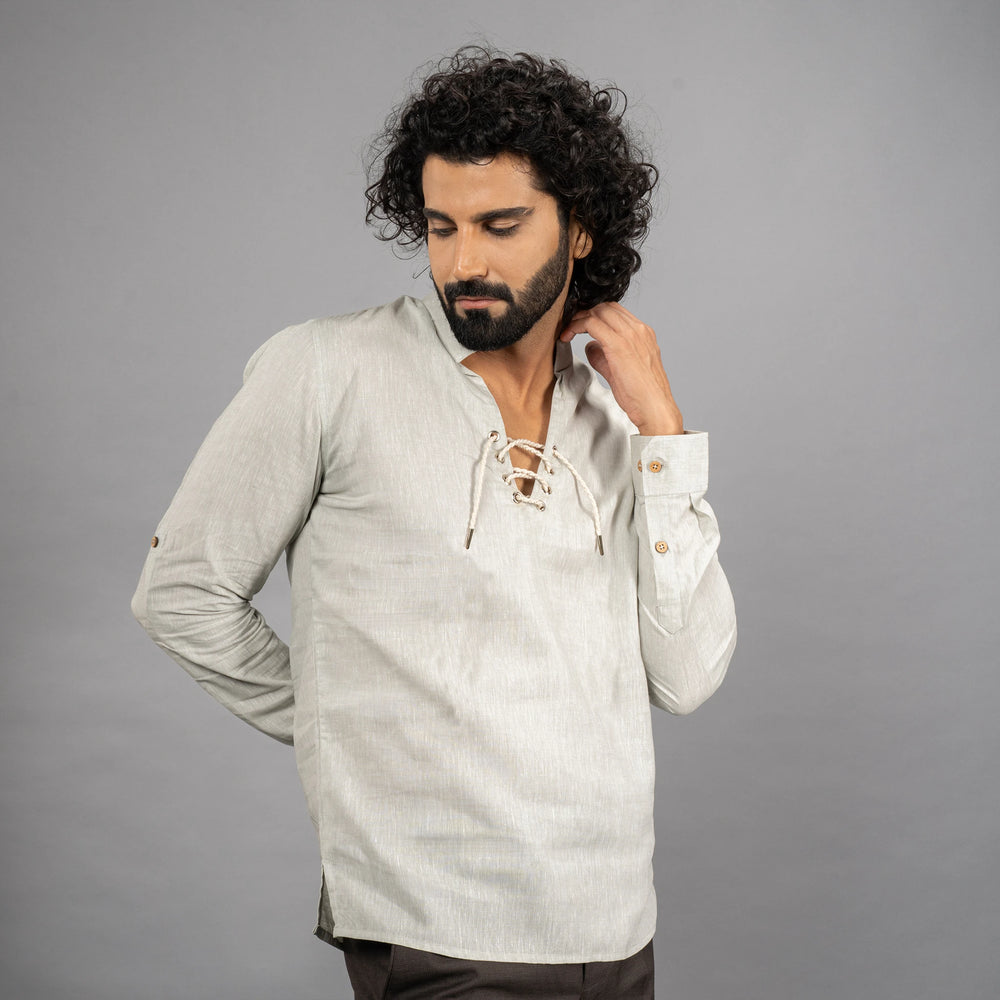 A maritime‑inspired lace‑up linen shirt with roll‑up sleeves, metal eyelets, and coconut shell button closures.