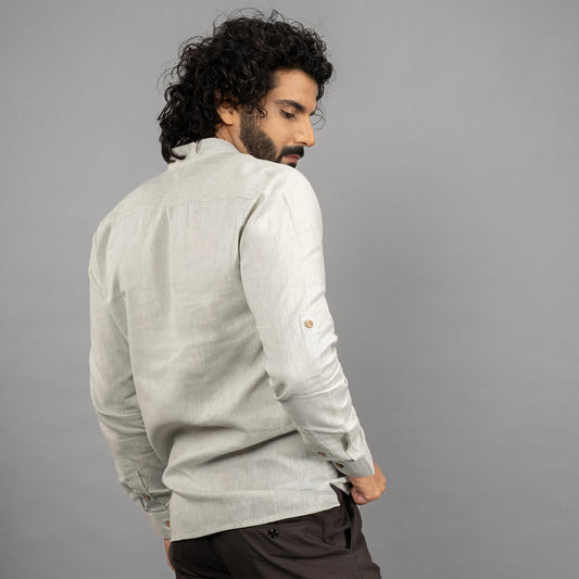 A maritime‑inspired lace‑up linen shirt with roll‑up sleeves, metal eyelets, and coconut shell button closures. posing backward