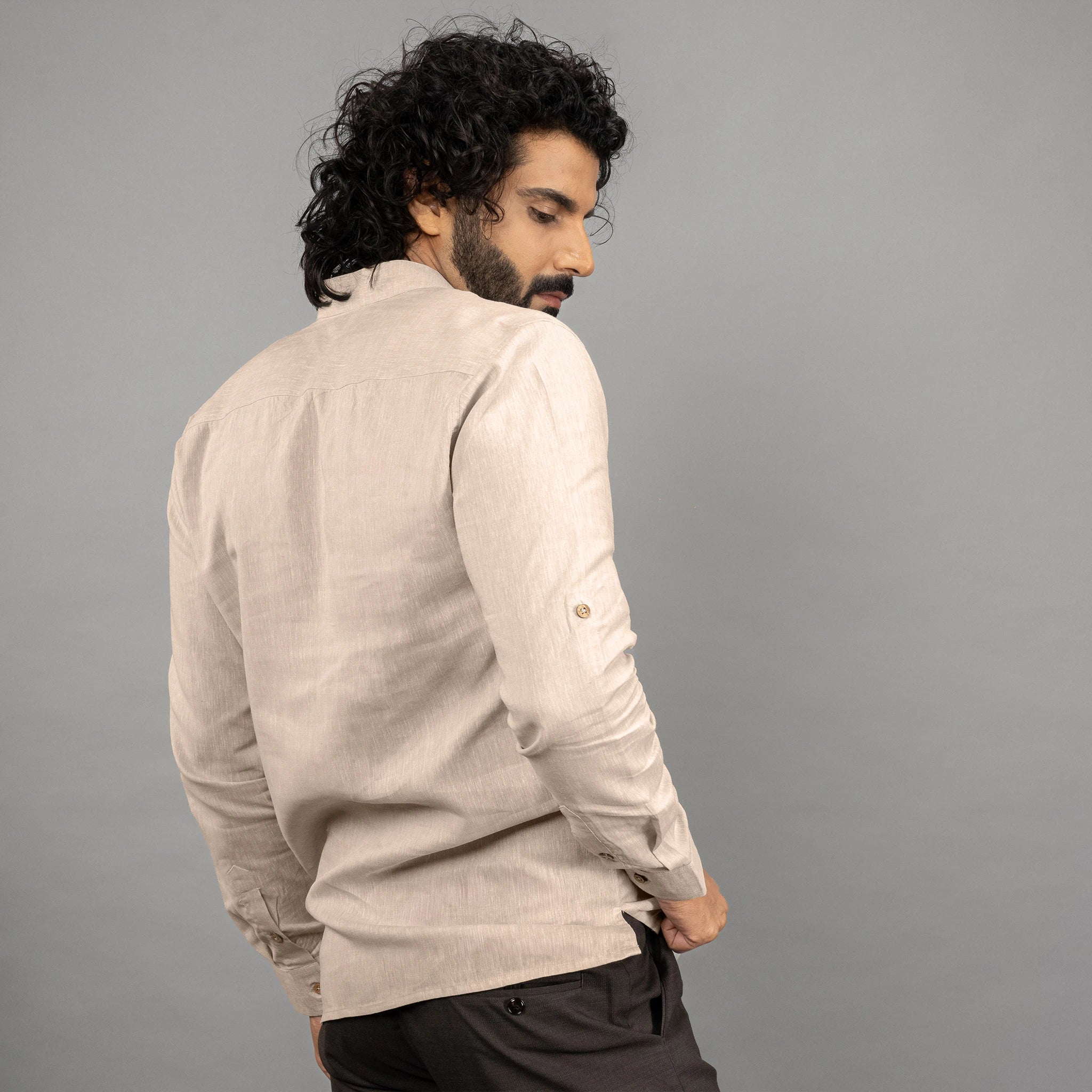 A maritime‑inspired lace‑up linen shirt with roll‑up sleeves posing backward