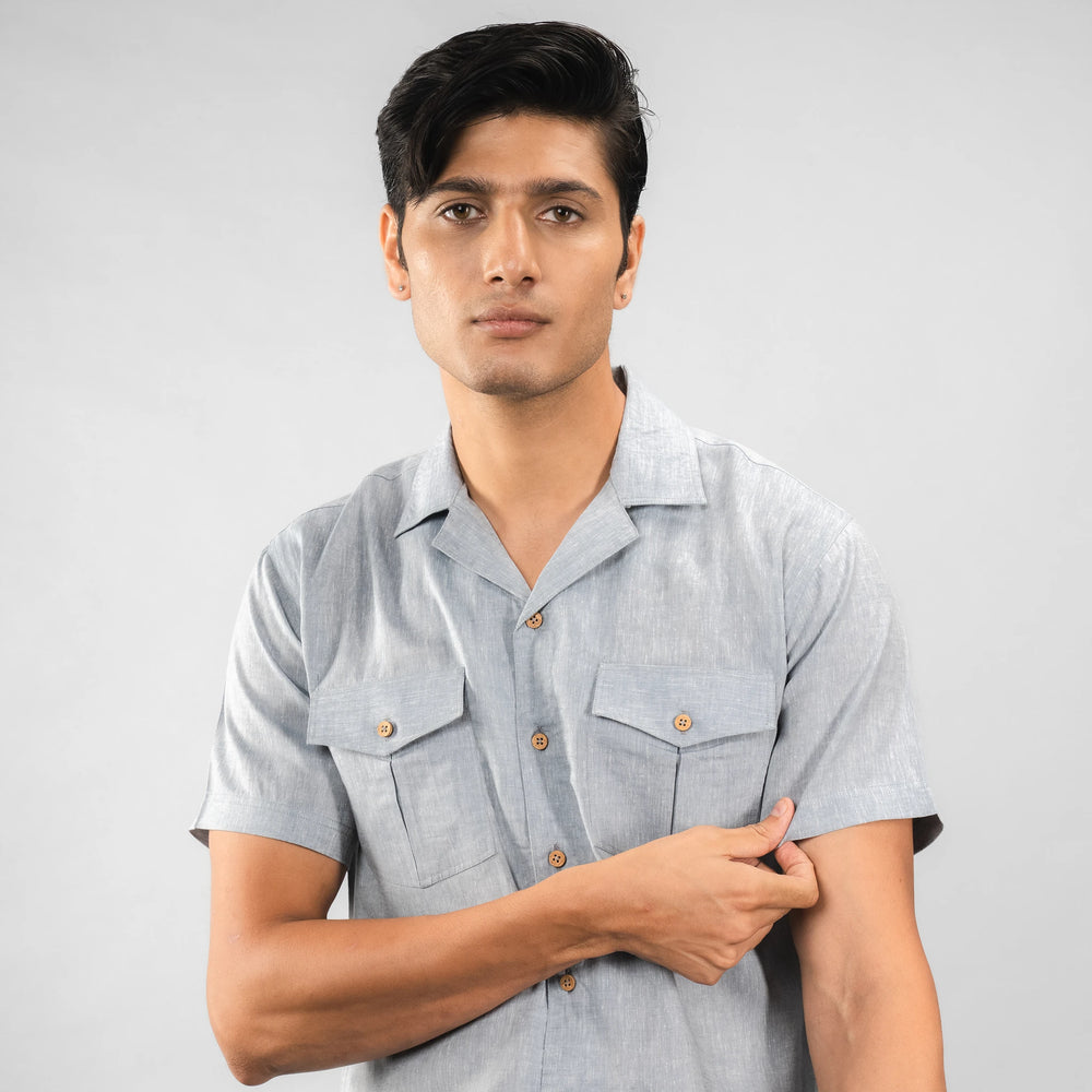 Man wearing a Faded Denim short-sleeve shirt with button details on a white background