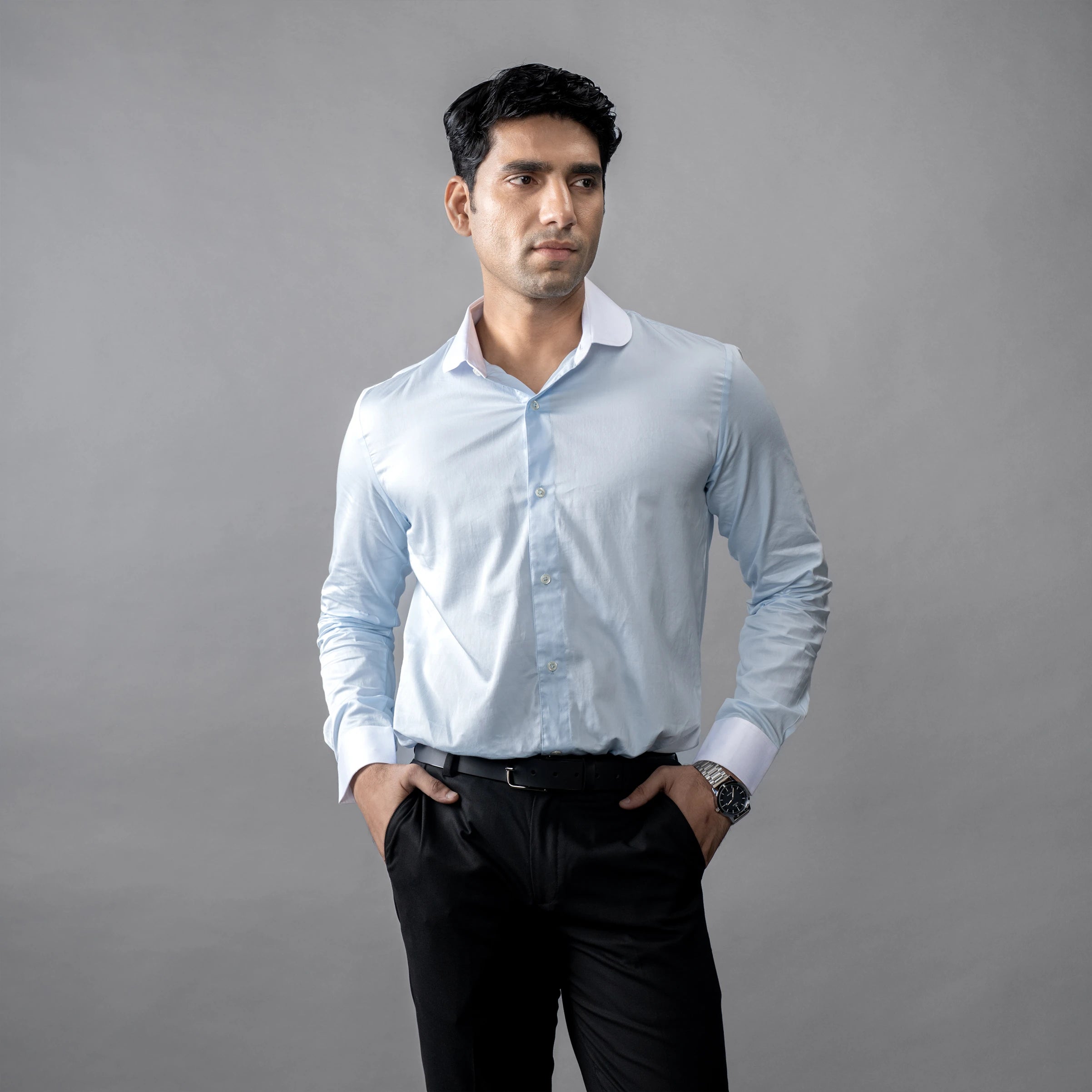 Man wearing a brand appril formal light blue shirt against a grey background