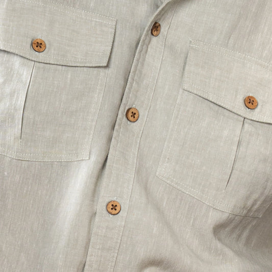 Close-up of a light oil green shirt with button details on a neutral background