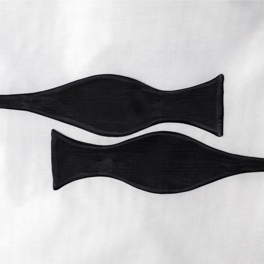 Two black satin  bow tie open pieces on a white background