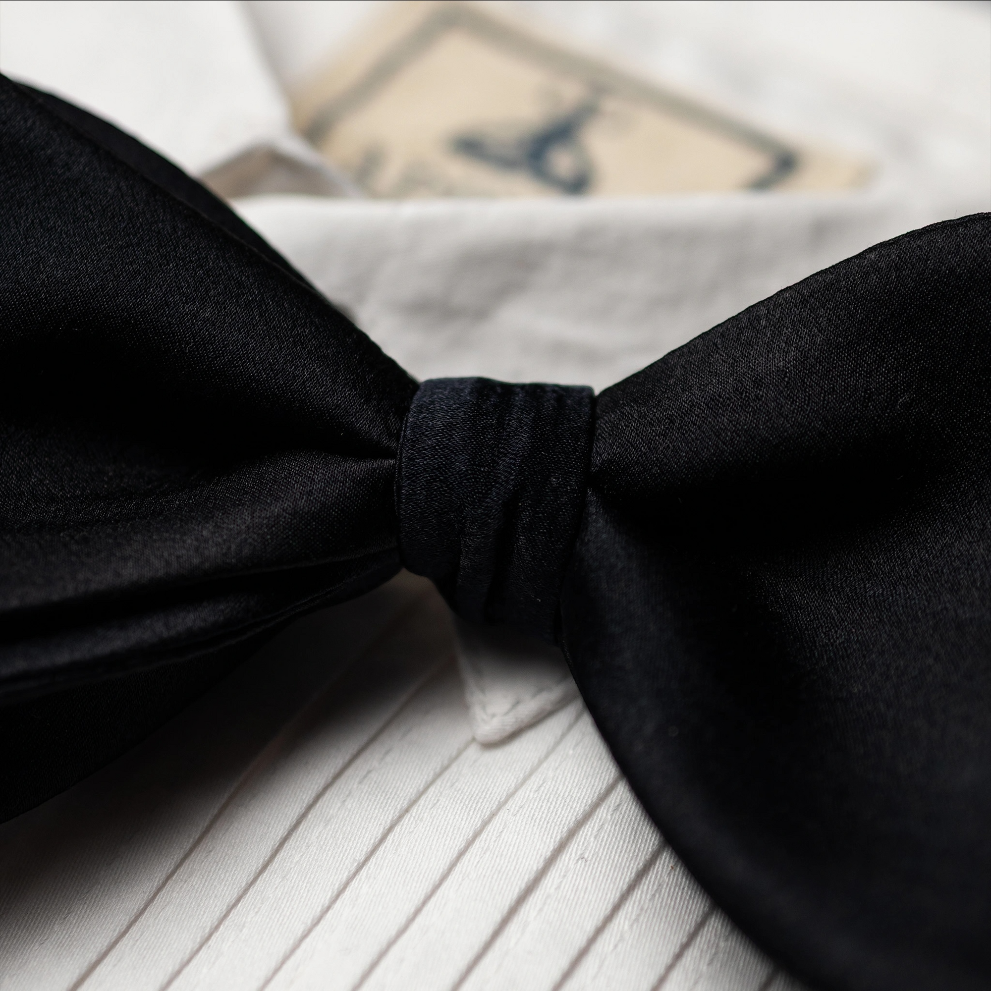 Black satin bow tie on a white shirt