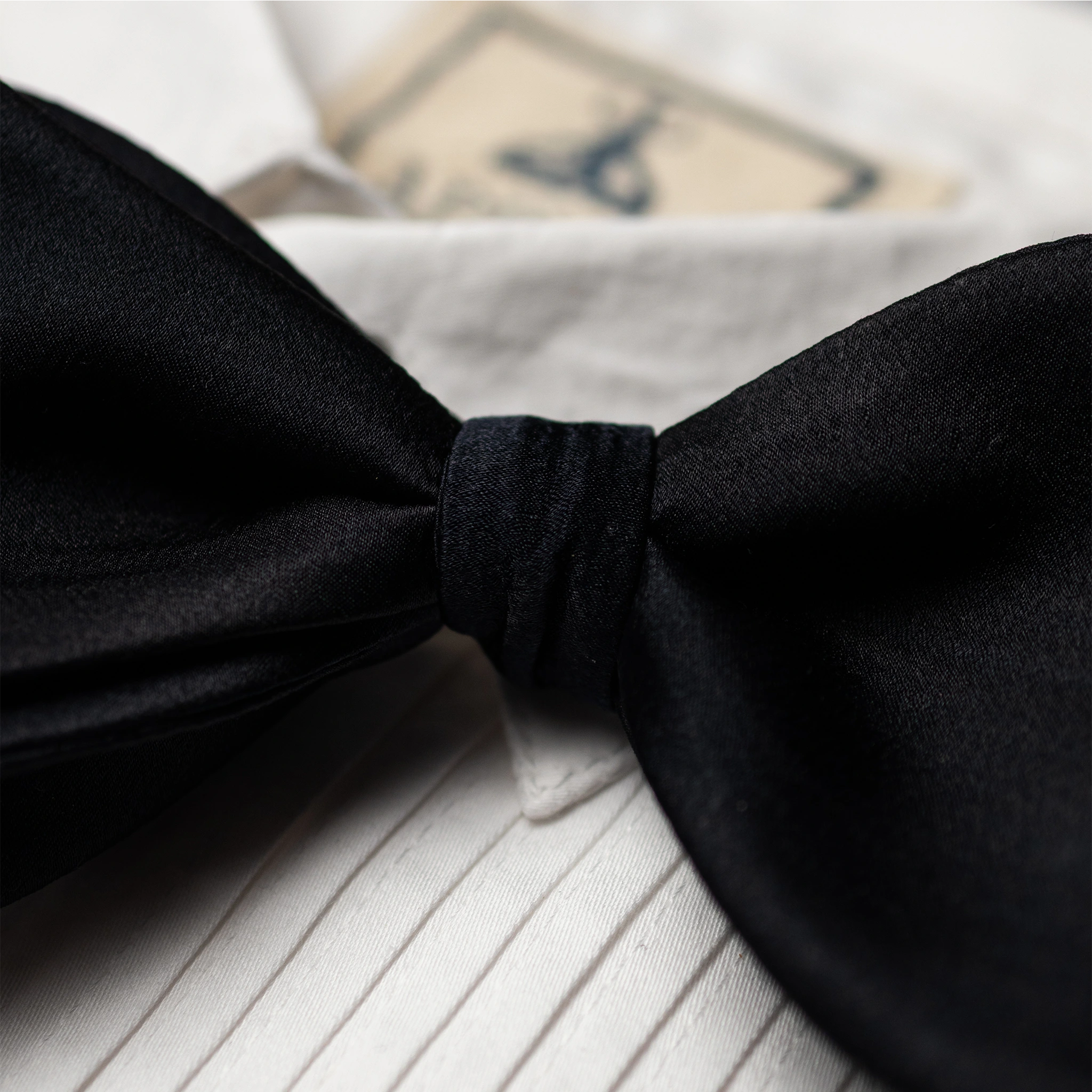 Black satin bow tie on a white shirt 